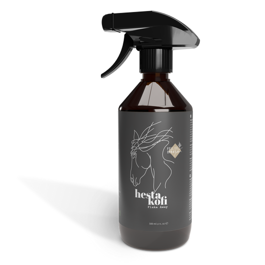 Eine dunkle Sprühflasche mit der Aufschrift Hestakofi Flake Away, mit einer minimalistischen Abbildung eines weißen Pferdekopfes und einem Hydration Complex zur Unterstützung der Hautbarriere. Die 500-ml-Flasche ist mit einem schwarzen Sprühkopf ausgestattet.
