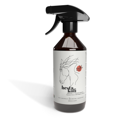 Eine braune Sprühflasche mit der Aufschrift "Hestakofi Woody Mandarine" zeigt auf ihrem weißen Etikett eine minimalistische Pferdekopfzeichnung. Die Flasche enthält natürliches Mähnen- und Schweifspray und ist mit einer schwarzen Abzugsdüse ausgestattet.